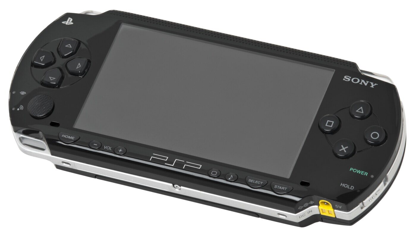 The original PSP-1000, the model that launched in December 2004: a 4.3-inch widescreen with the analogue nub below the d-pad and the UMD drive round the back.